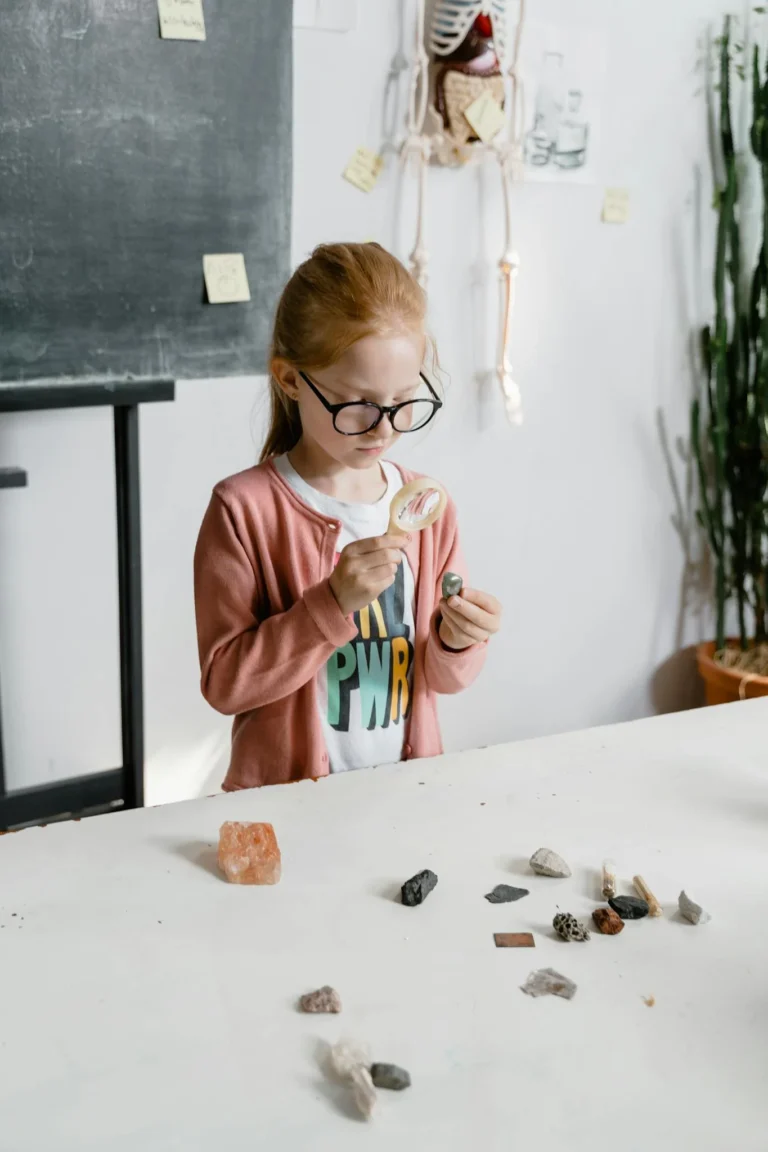 A curious child examines rocks using a magnifying glass, fostering interest in science.